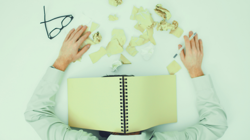 Overthinking and planning overwhelmed man covered in papers